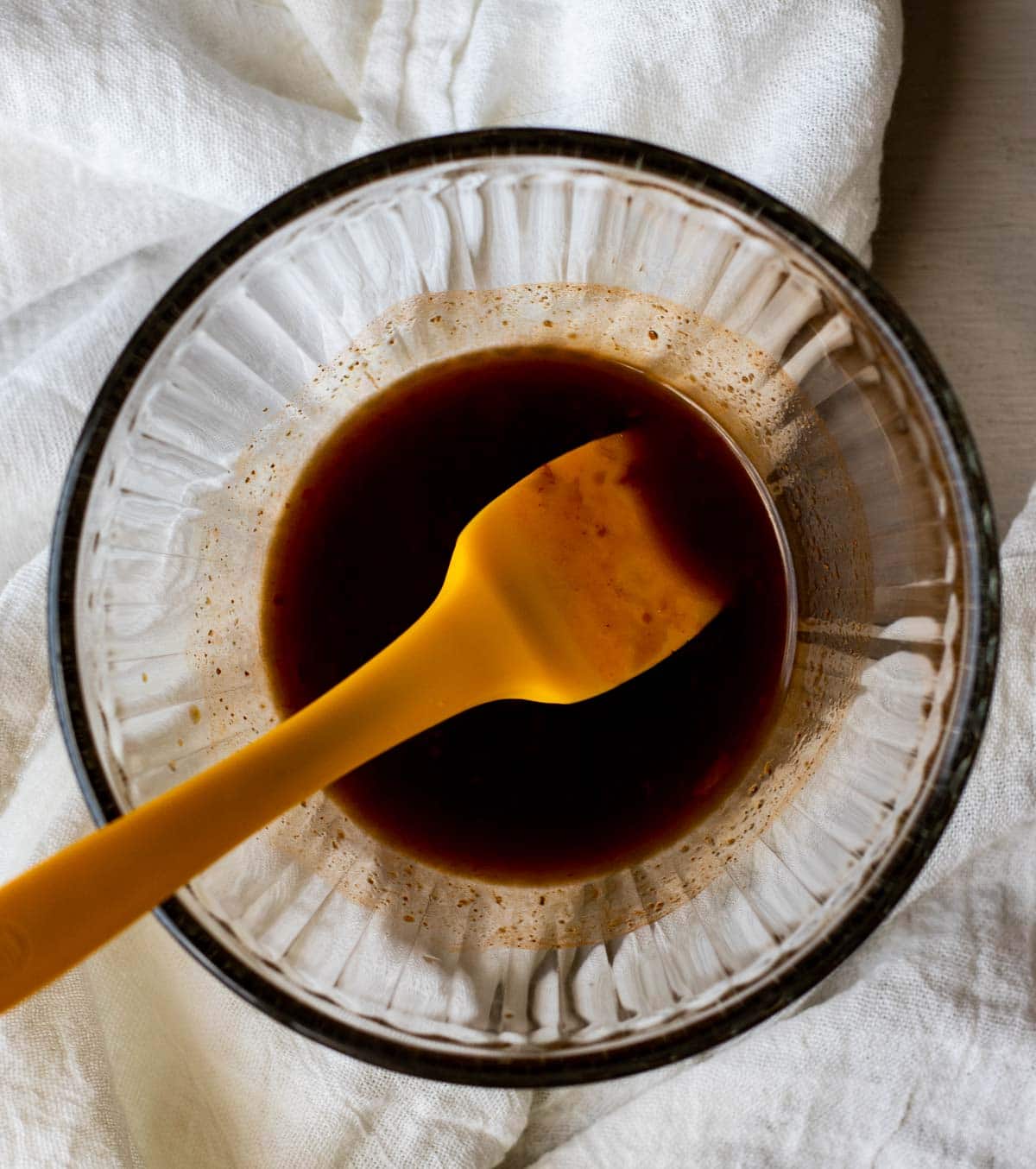 Hunan sauce in a glass bowl with a spatula.