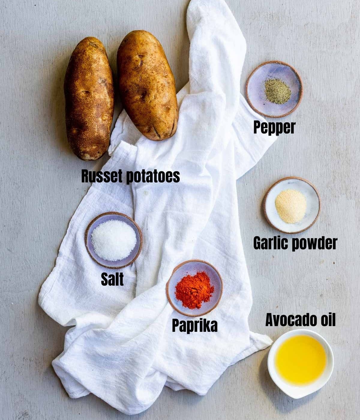 Ingredients to make air fryer breakfast potatoes arranged individually and labelled.
