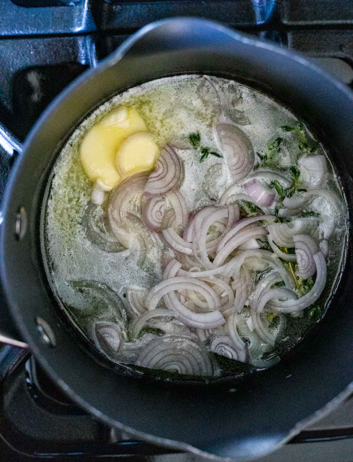 Grapefruit and shallot sauce cooking in a pot on the stovetop.