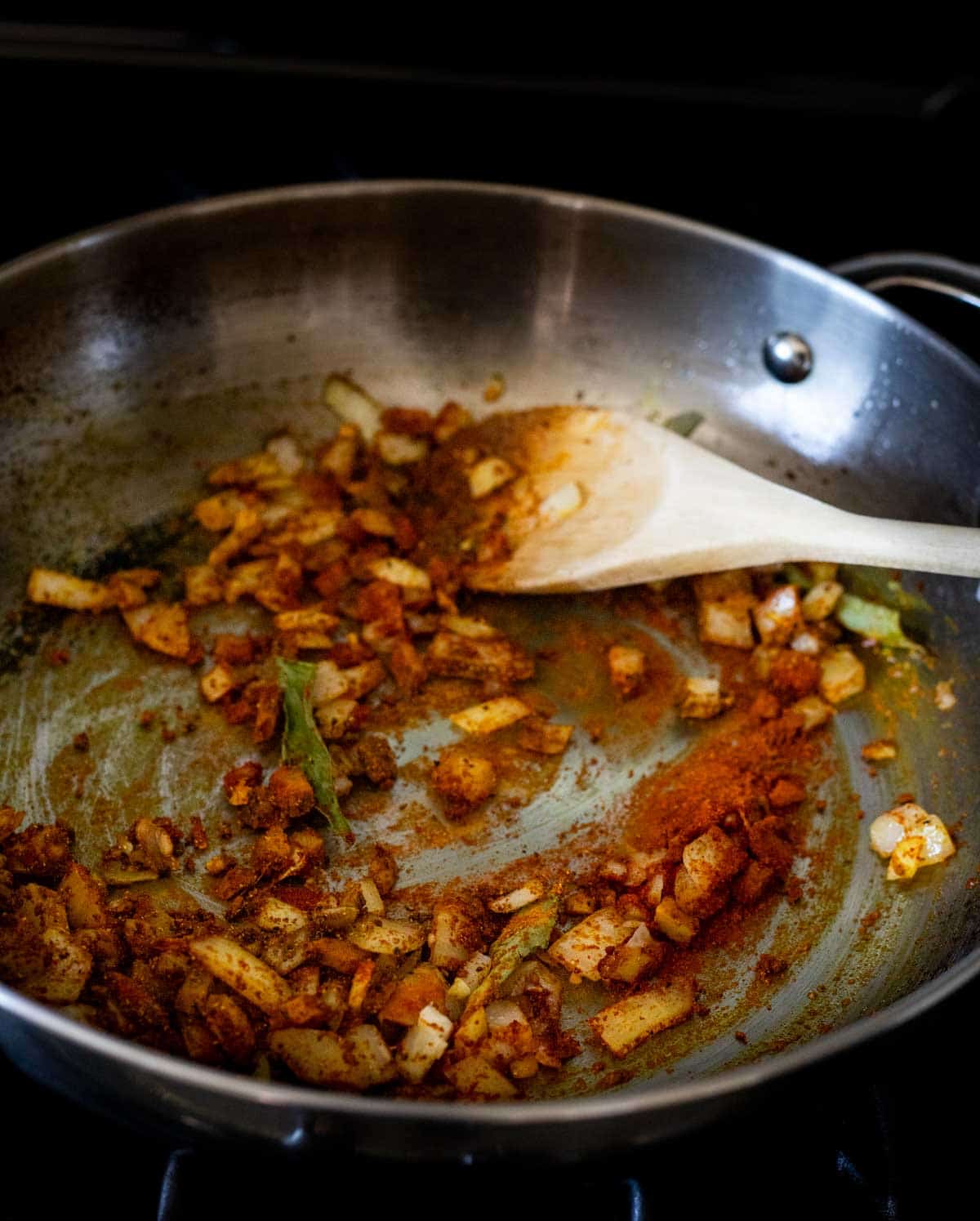 Garlic, ginger, onion, spices and curry leaves sautéing in a skillet.