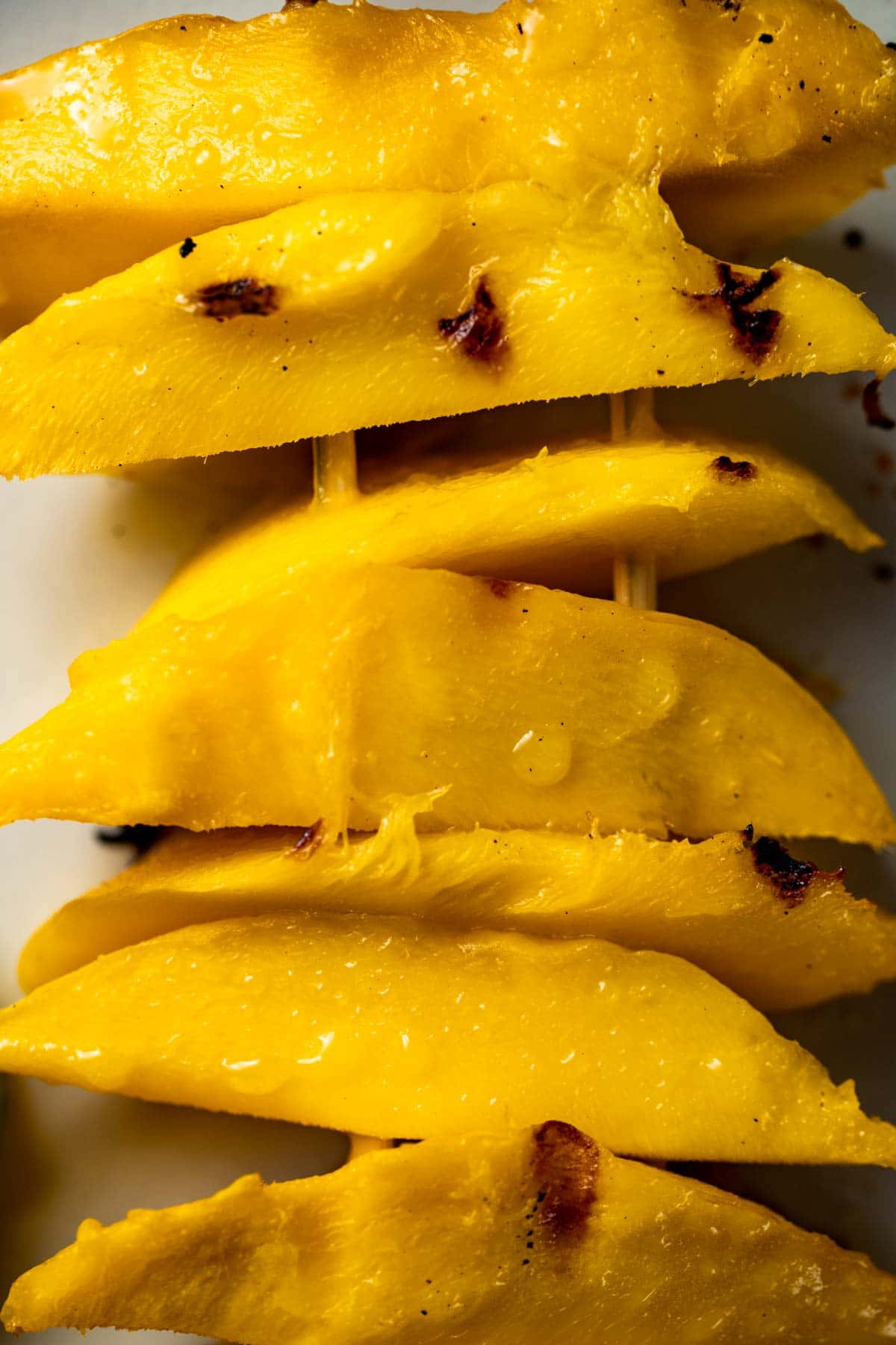 Overhead close up view of grilled mango slices.