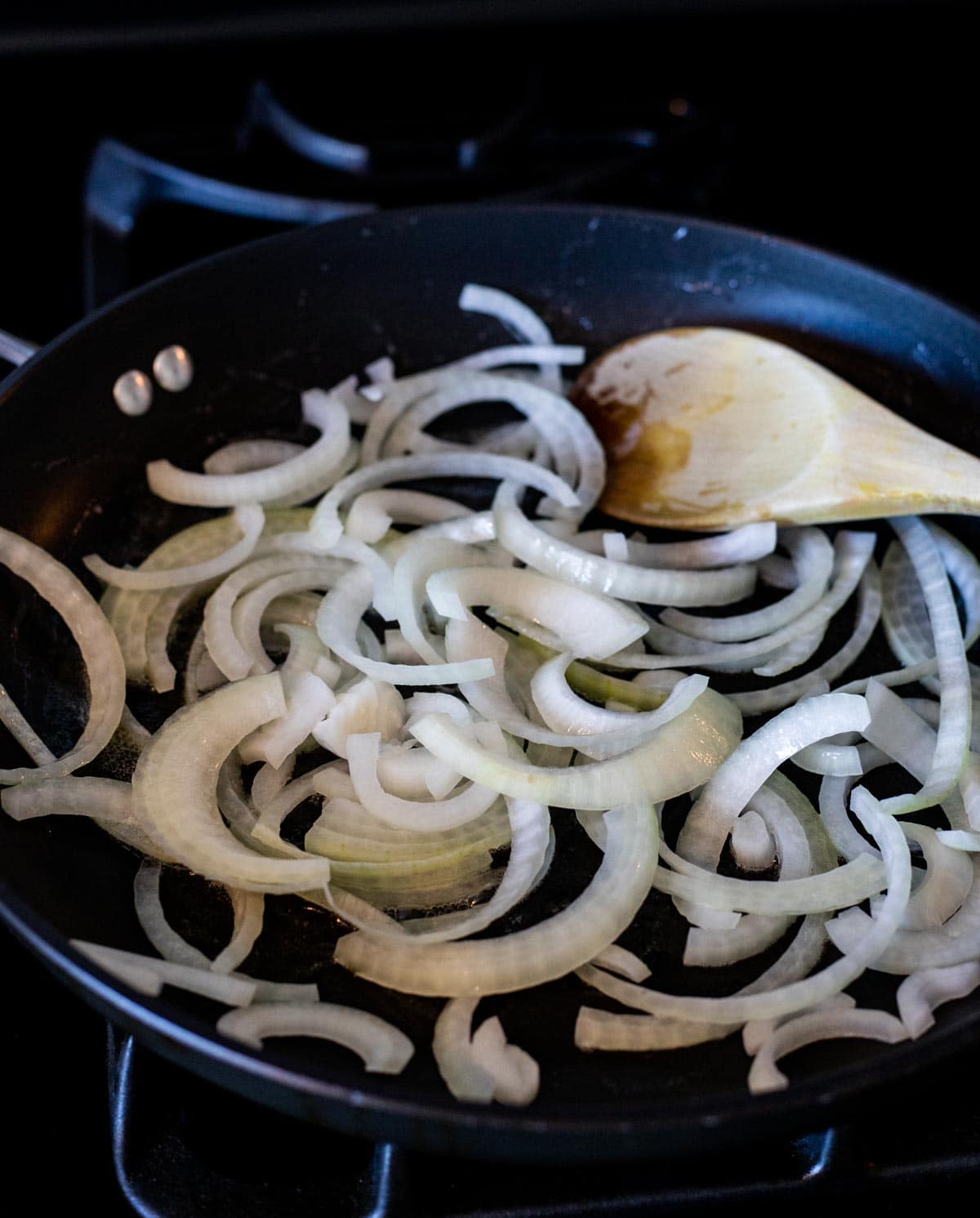 Sliced onions sautéing in a skillet.