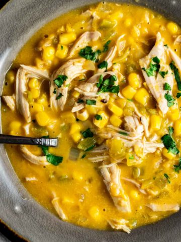 Close up view of corn and chicken soup in a bowl.