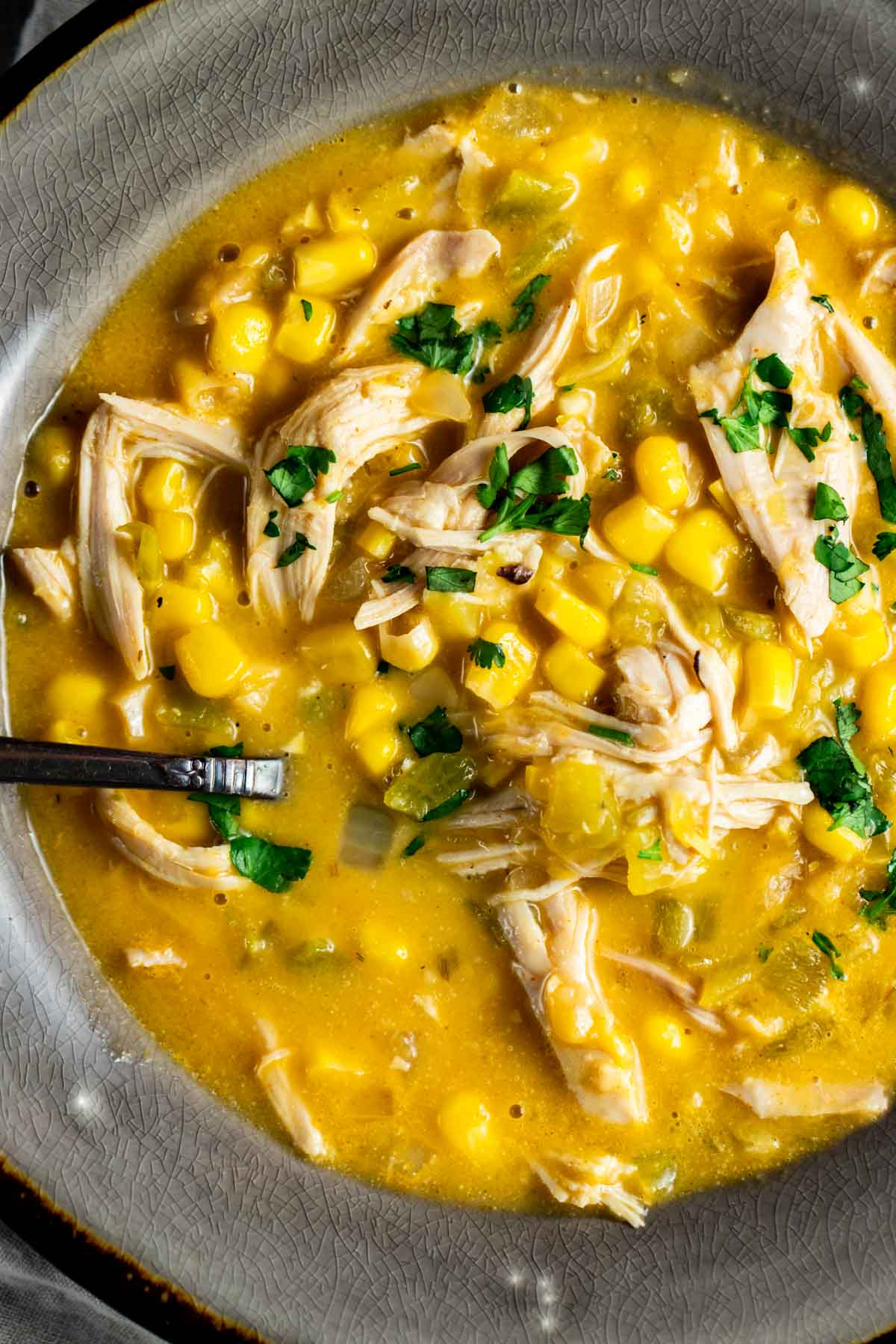 Close up view of corn and chicken soup in a bowl.