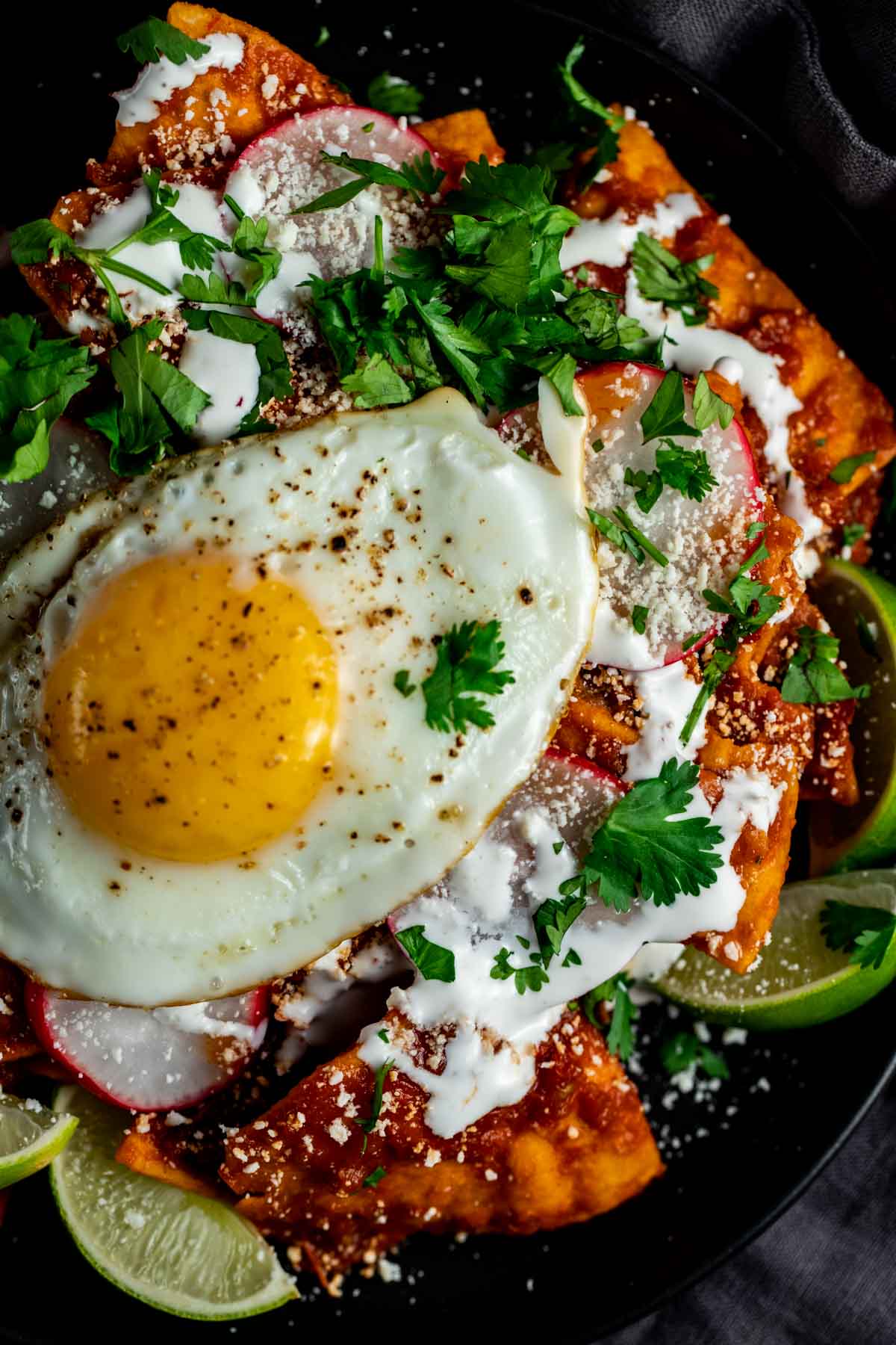 Overhead view of a fried egg on top of chilaquiles rojos.