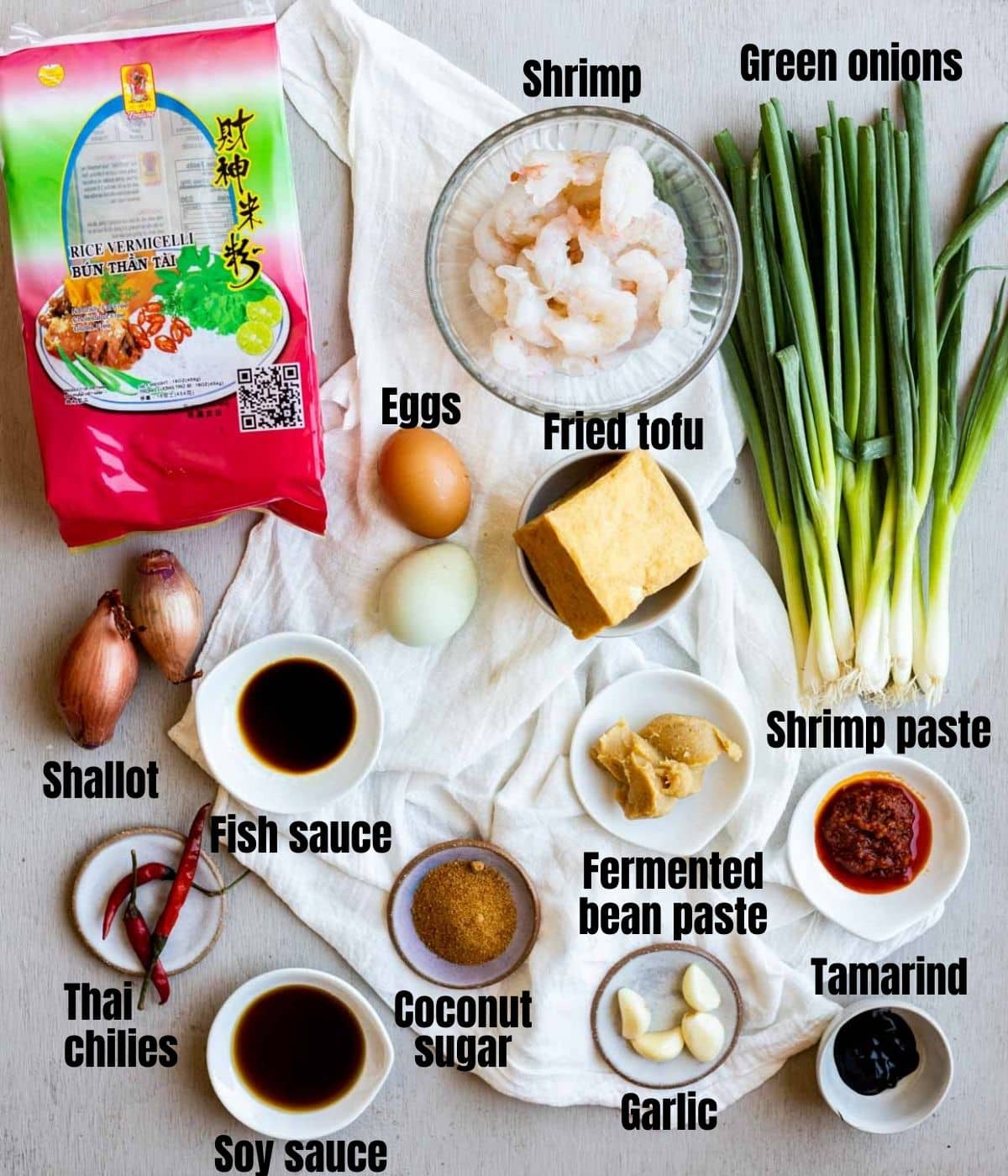 Ingredients to make mee siam arranged individually and labelled.