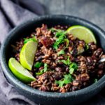 Instant Pot black beans and rice served in a bowl with lime wedges.