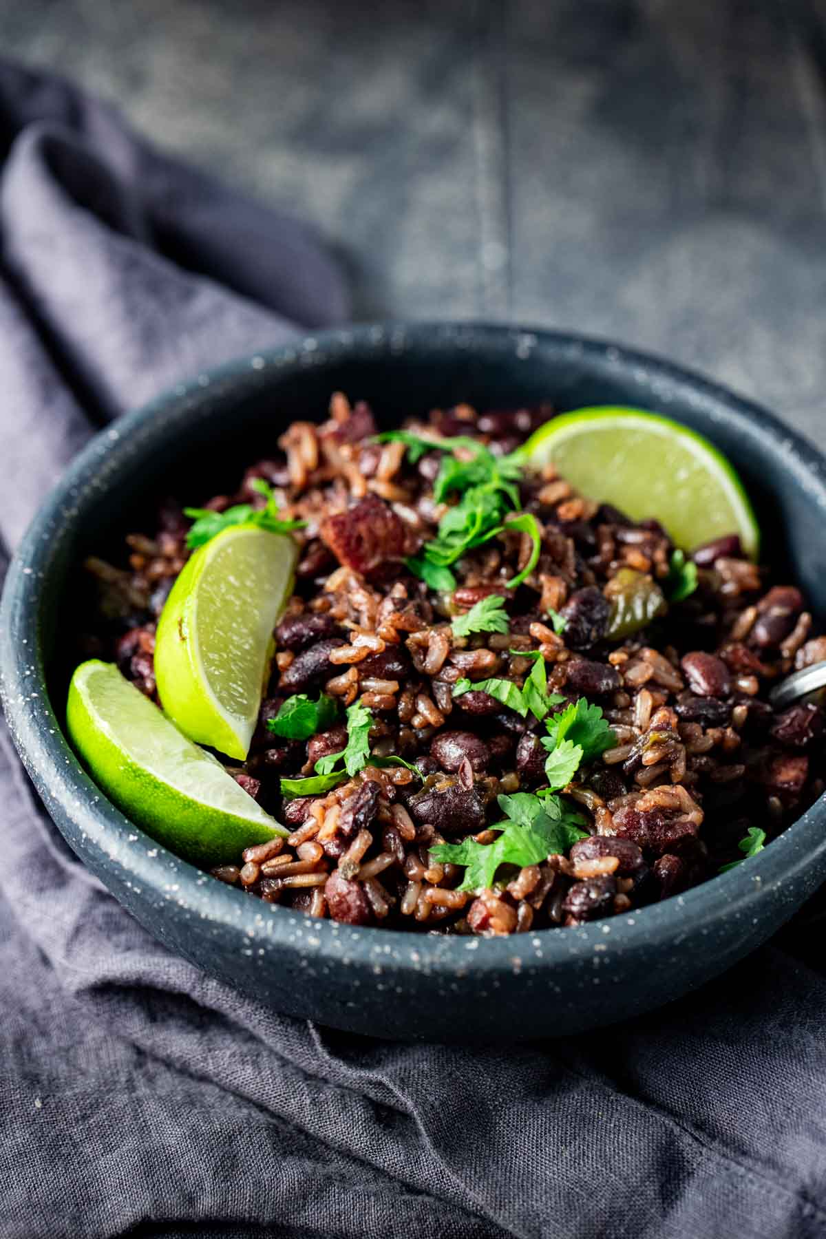 Instant Pot black beans and rice served in a bowl with lime wedges.