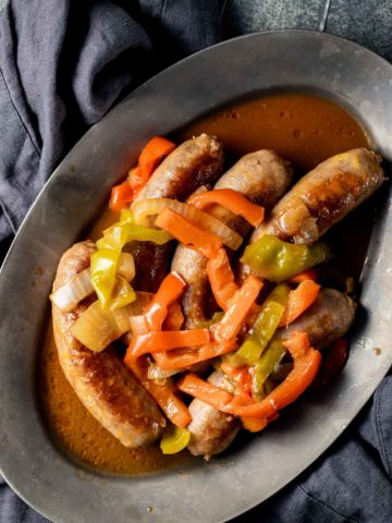 Overhead view of Instant Pot sausage and peppers on an oval platter.