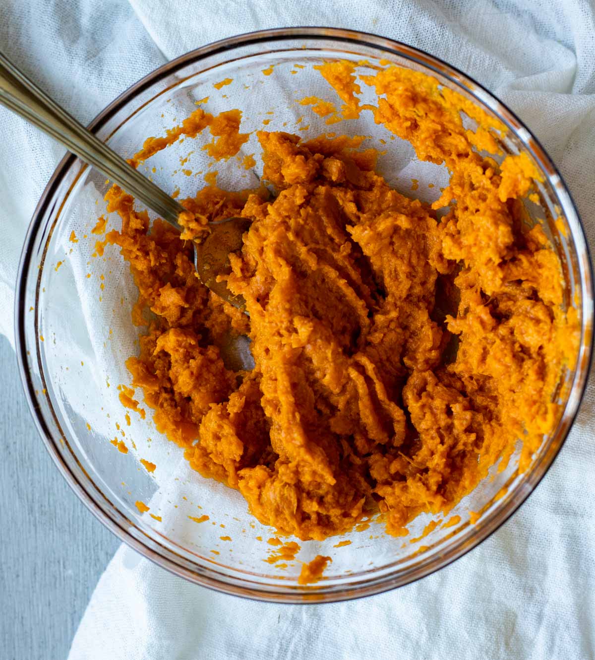 Mashed sweet potato in a glass bowl.