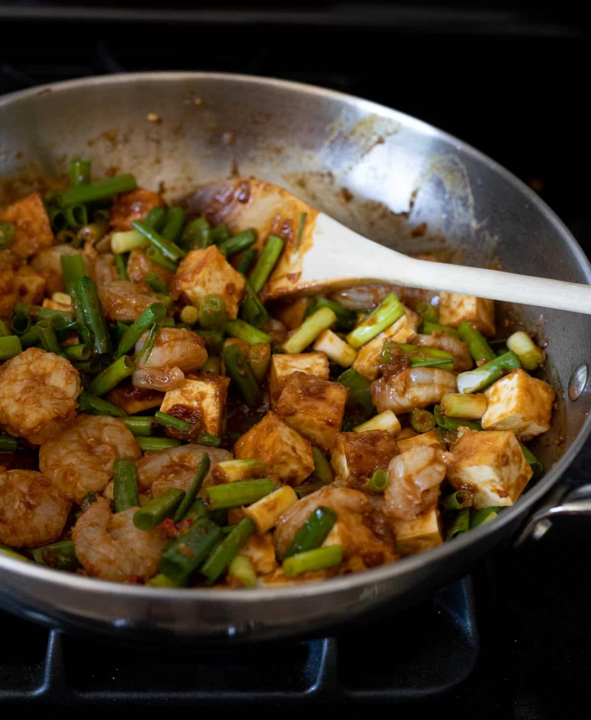 Green onions added to the skillet with the shrimp and tofu.