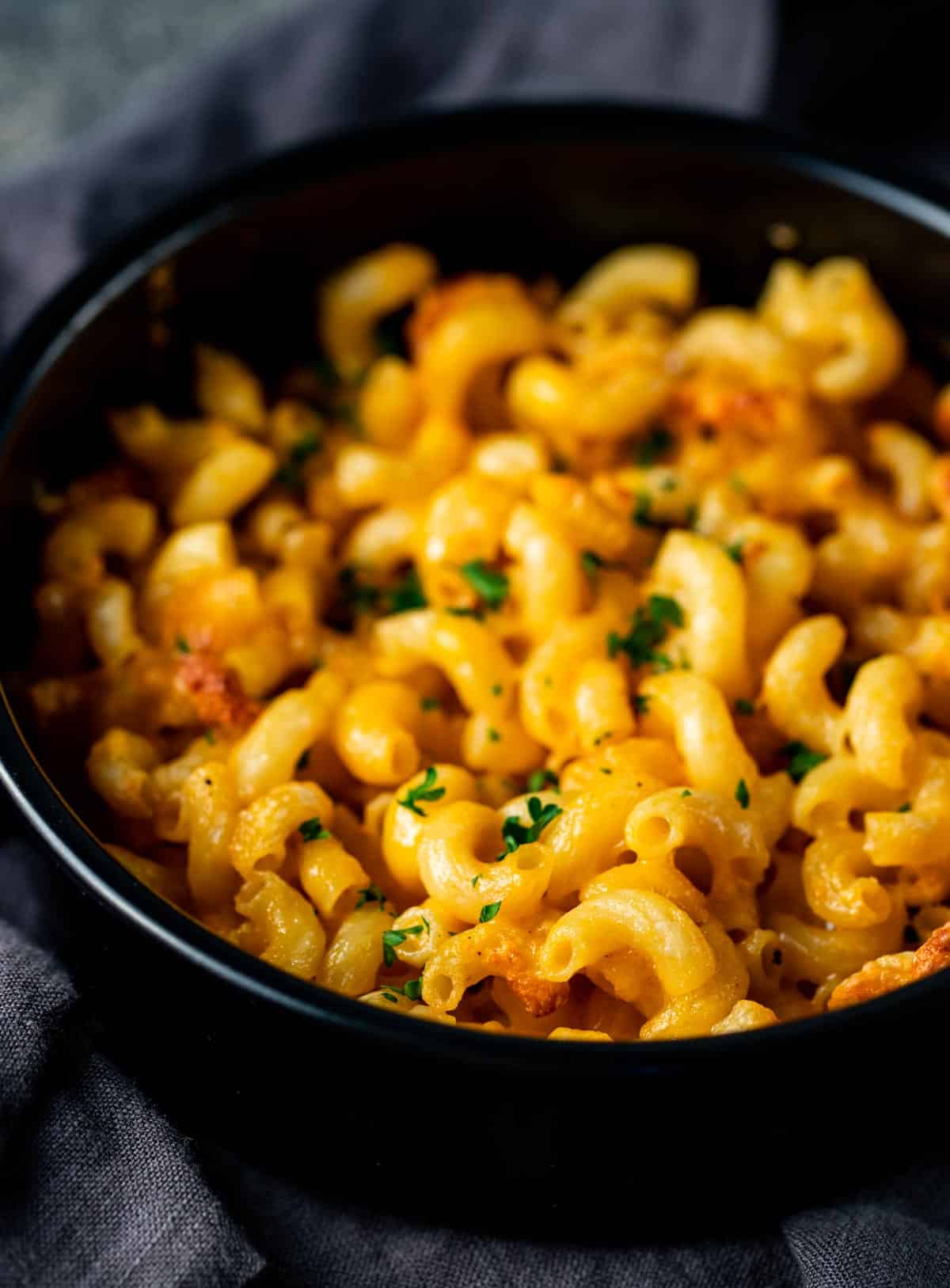 Close up view of mac and cheese in a black pan.