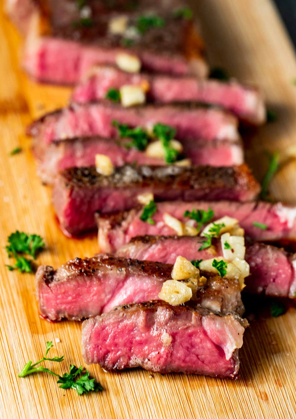 Sliced sous vide steak on a wooden cutting board.