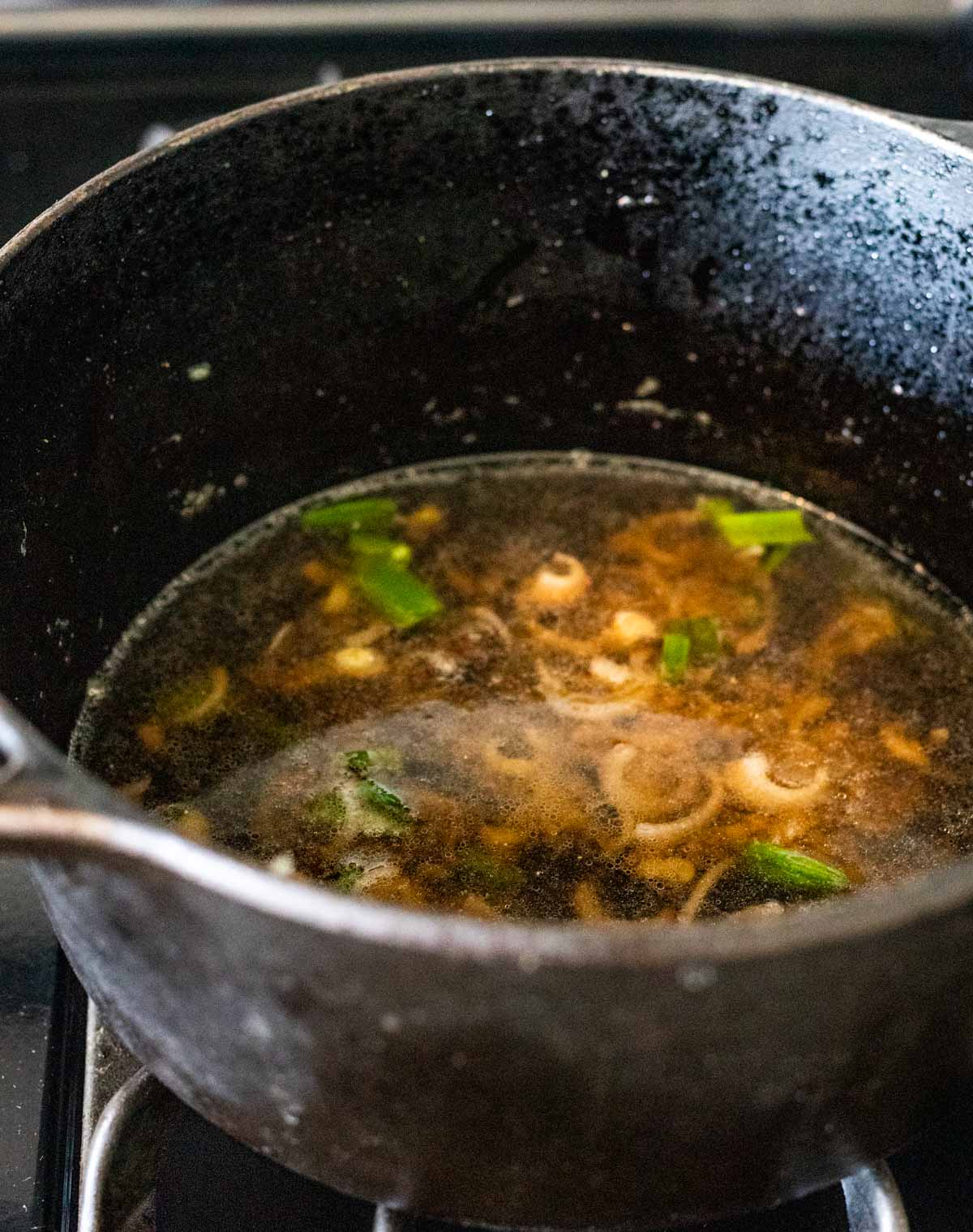 Soy sauce broth simmering in a large pot.