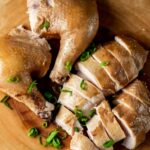 Soy sauce chicken cut into pieces and topped with green onions.