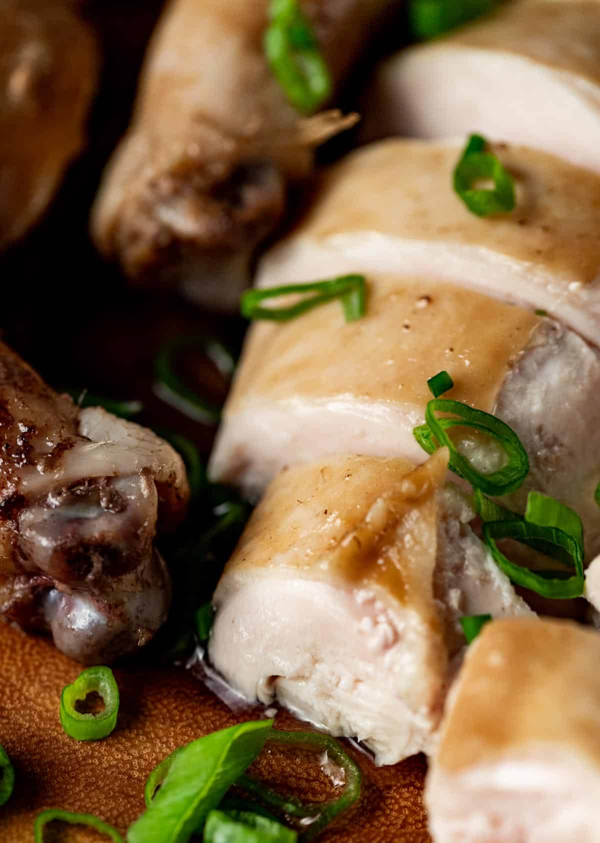 Close up view of a piece of soy sauce chicken.