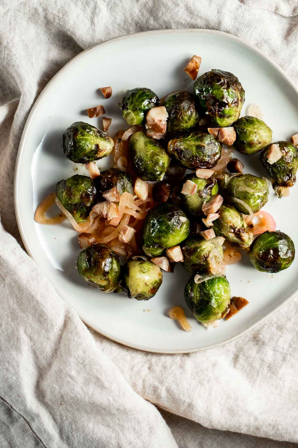 Overhead view of air fried Brussels sprouts on a white plate.