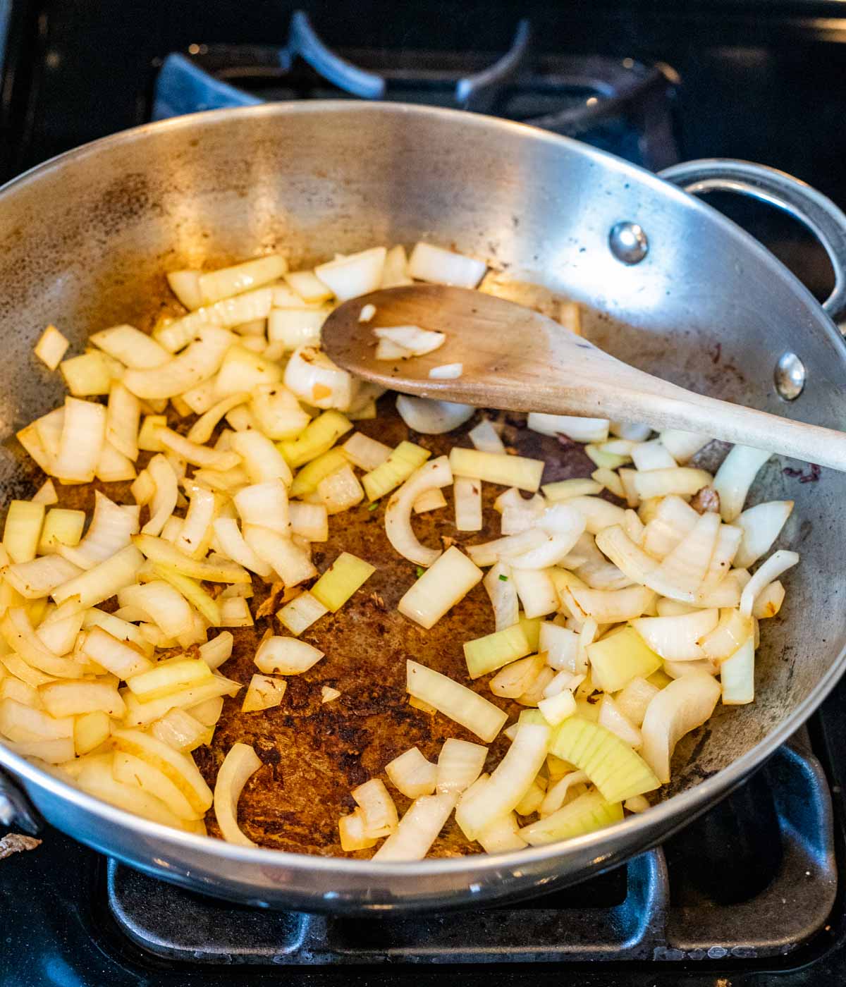 Onions sautéing in a skillet on the stovetop.