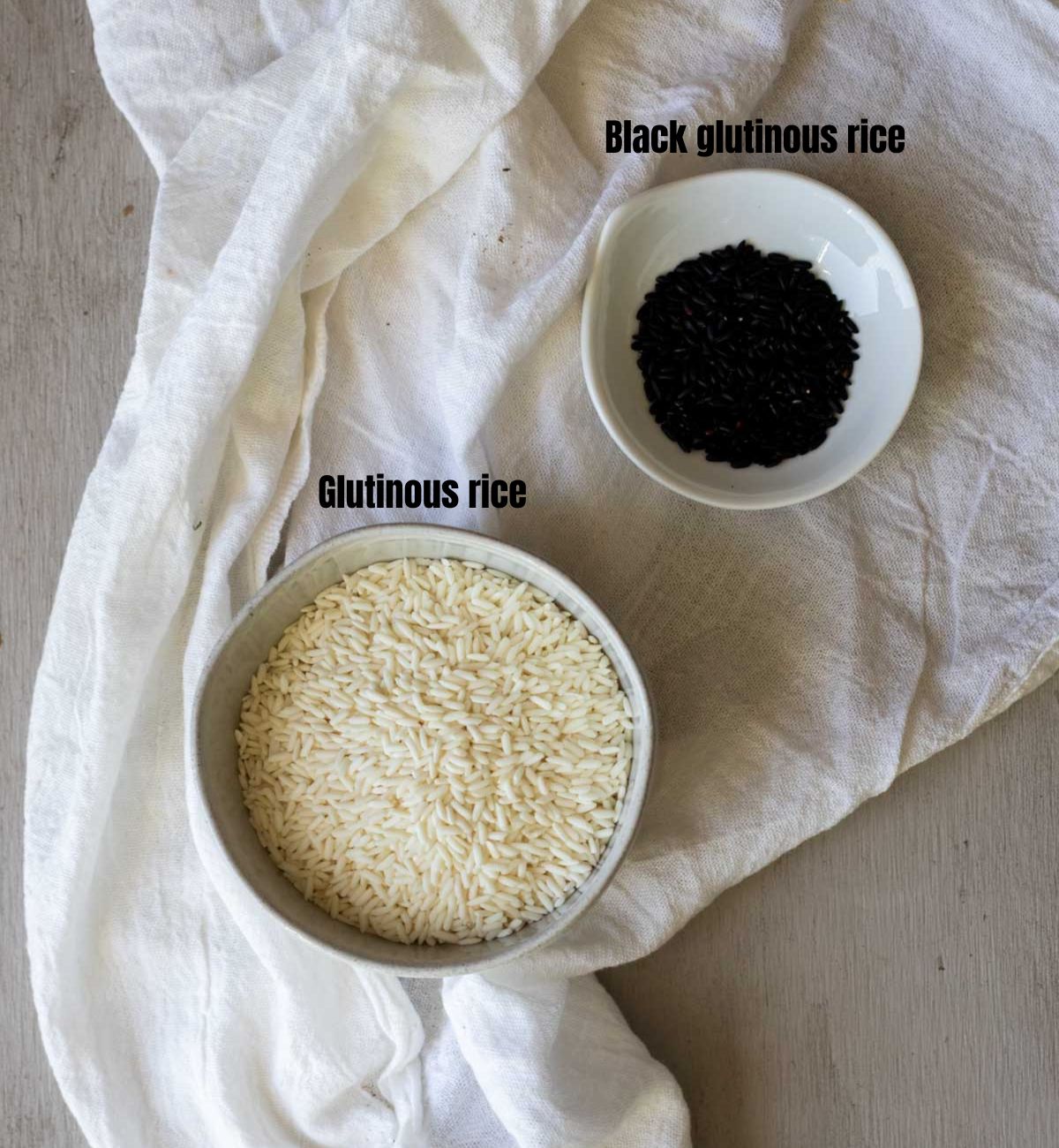 Glutinous rice and black glutinous rice in white bowls.