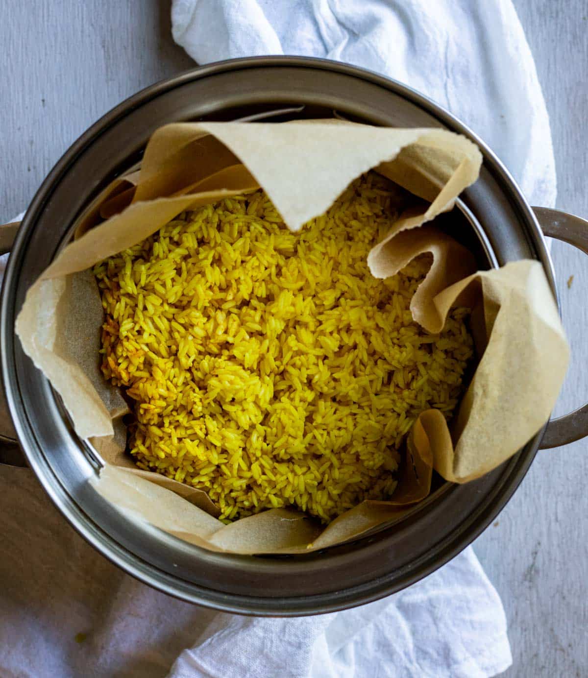 Turmeric rice in a parchment paper lined rice steamer.