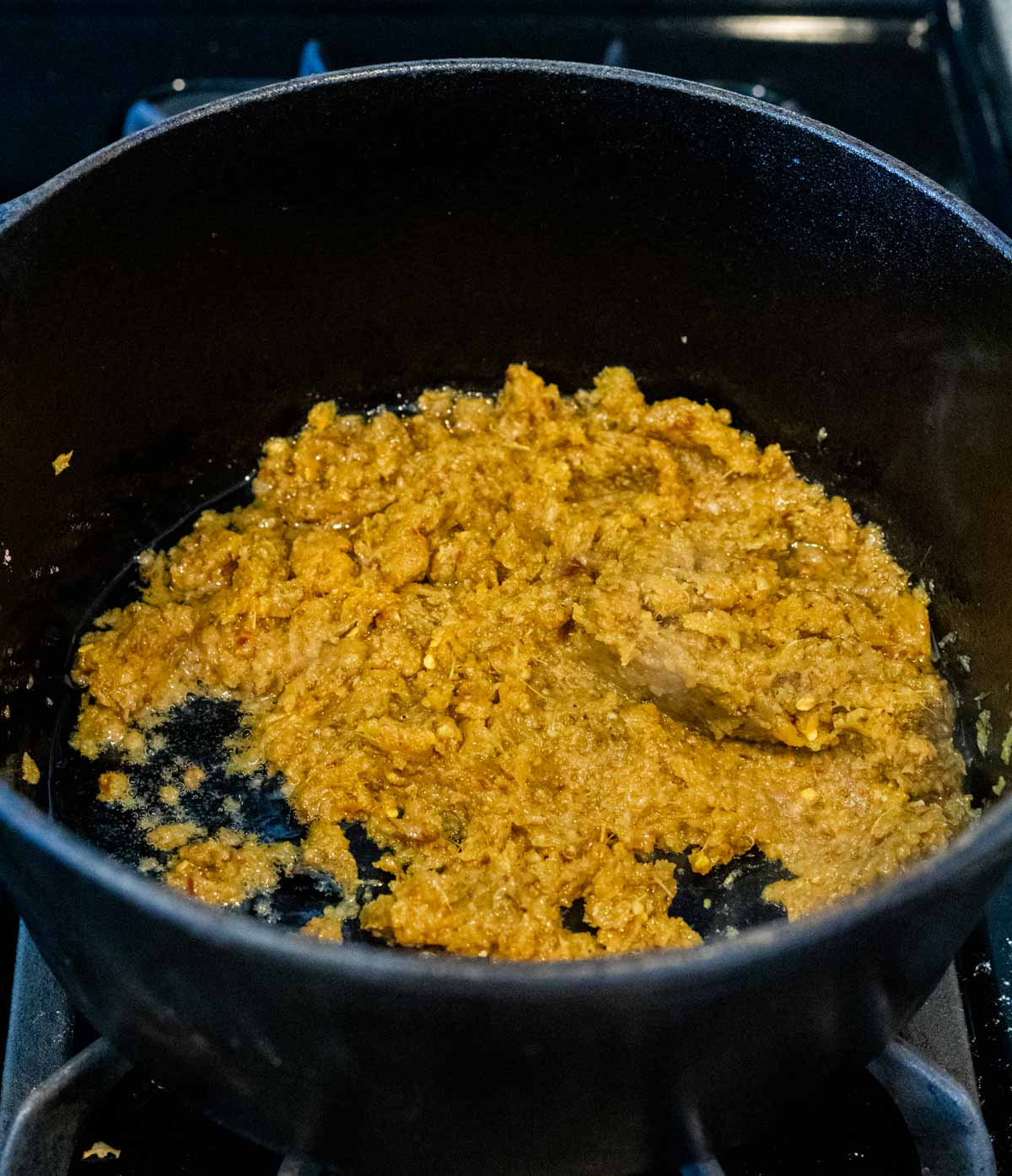 Spice paste cooking in a Dutch oven on the stovetop.
