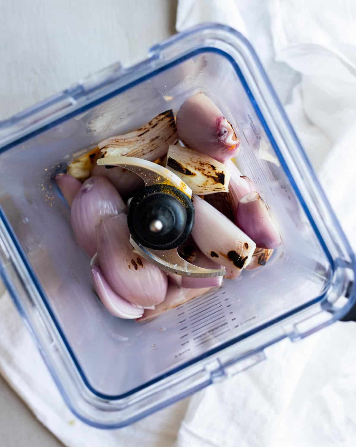 Charred shallots and garlic for the spice paste in a blender.