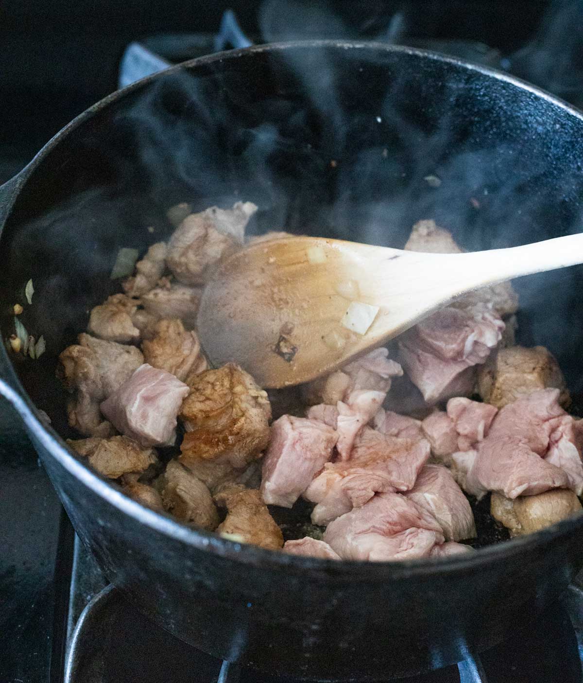 Pieces of veal browning in a Dutch oven on the stovetop.