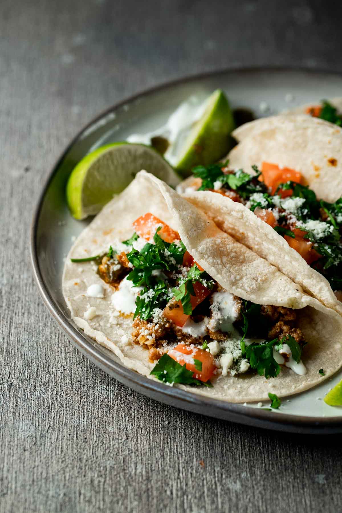 limes and multiple tacos on a plate ready to be eaten