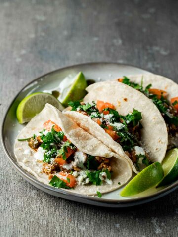 tacos on a plate with limes