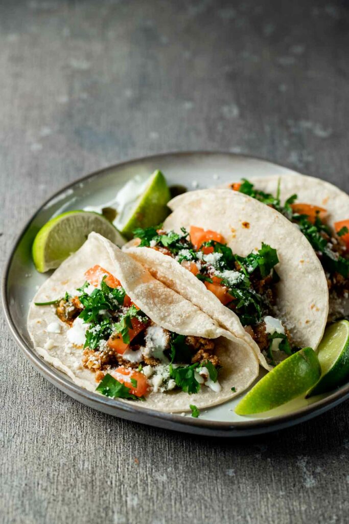 tacos on a plate with limes
