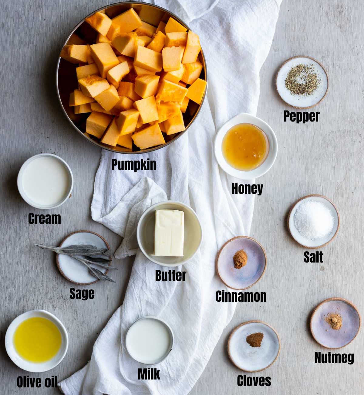 Ingredients to make mashed pumpkin arranged in individual dishes and labeled.