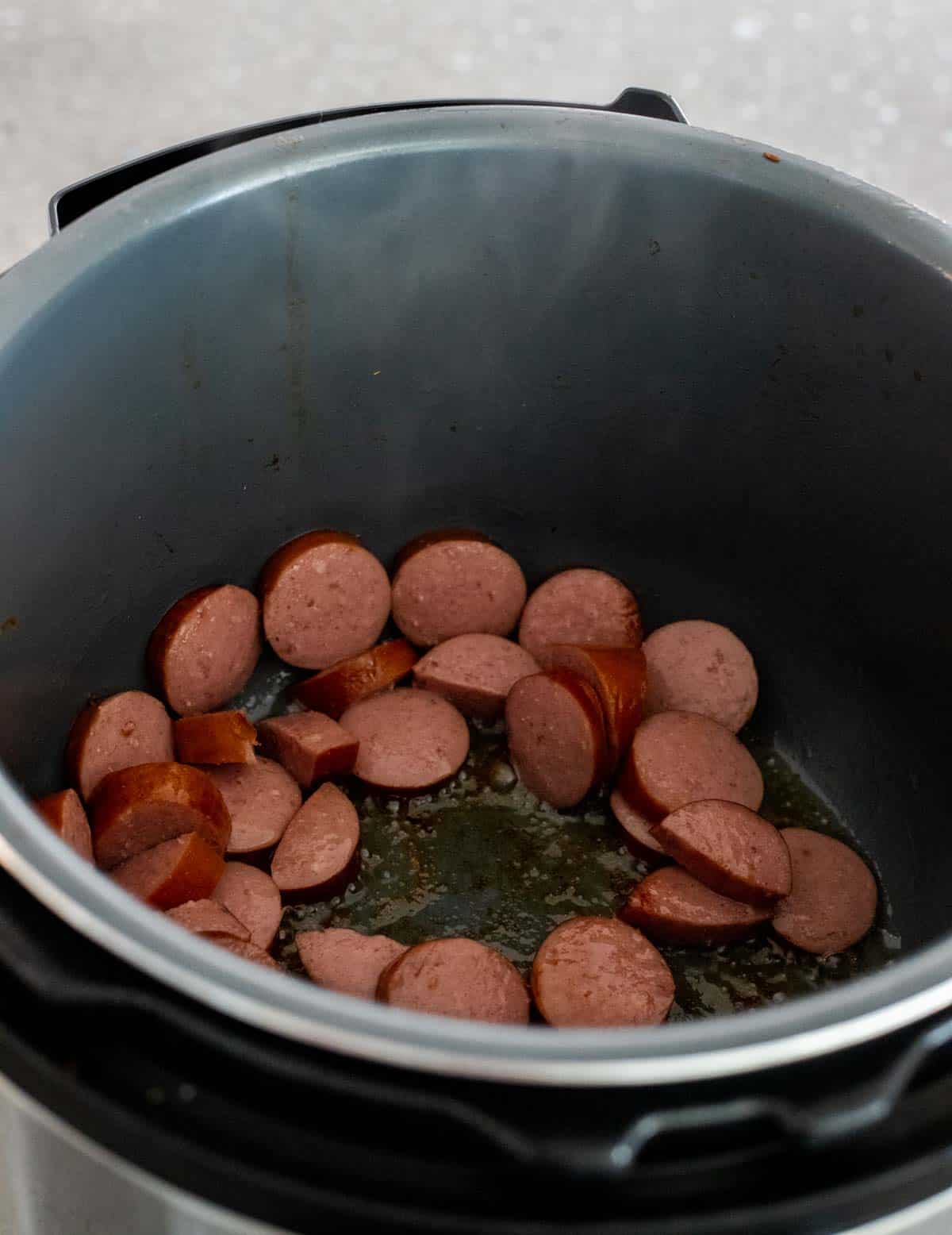 Sliced sausage browning in the Instant Pot.
