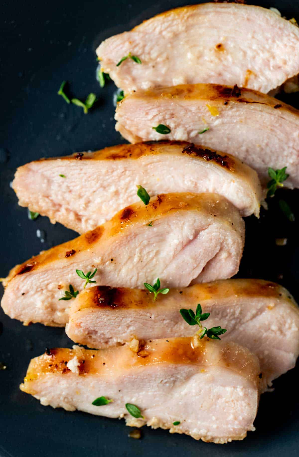 Close up view of sliced sous vide frozen chicken breast on a plate.