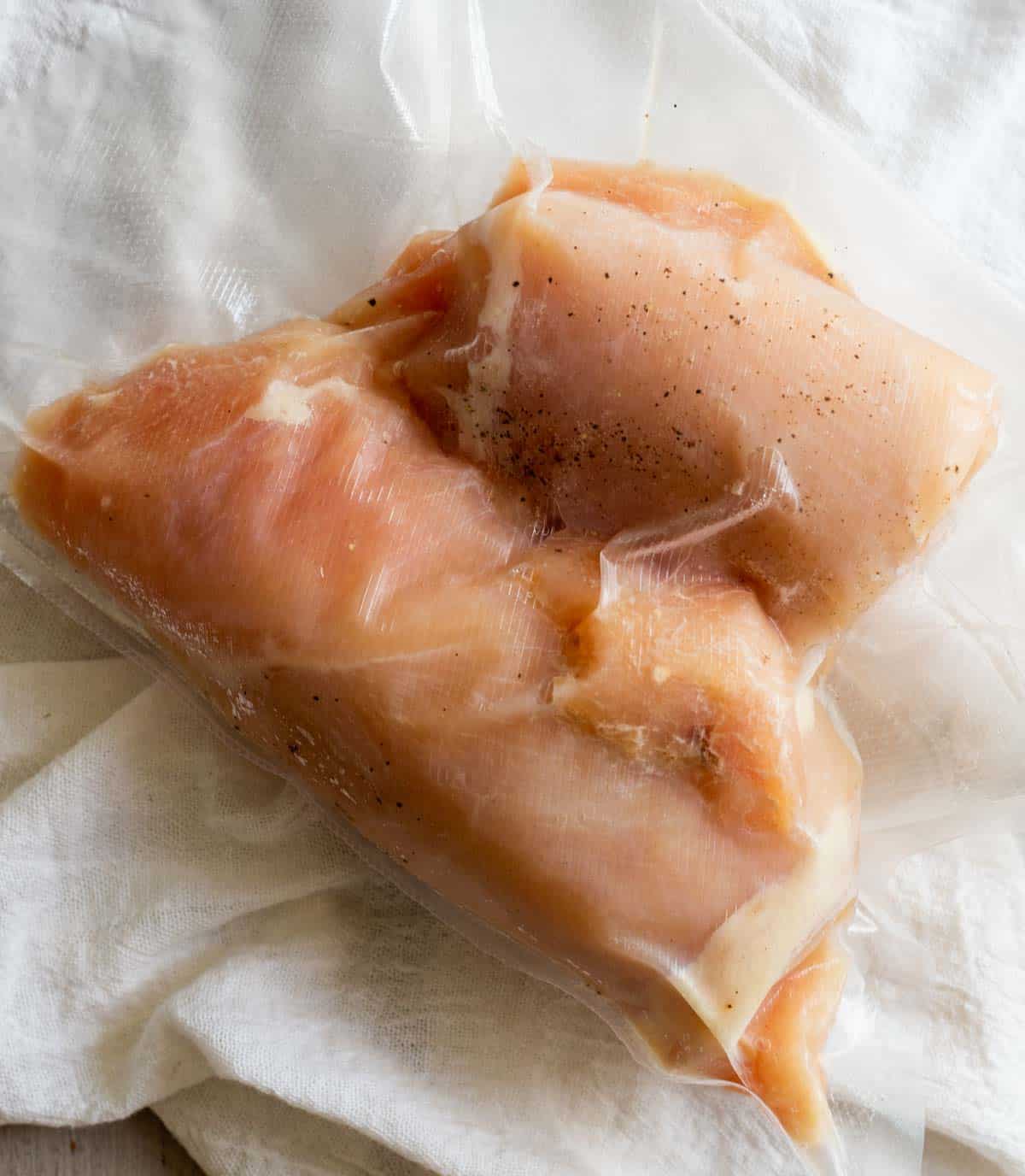 rolled up chicken breast in a bag ready to be cooked