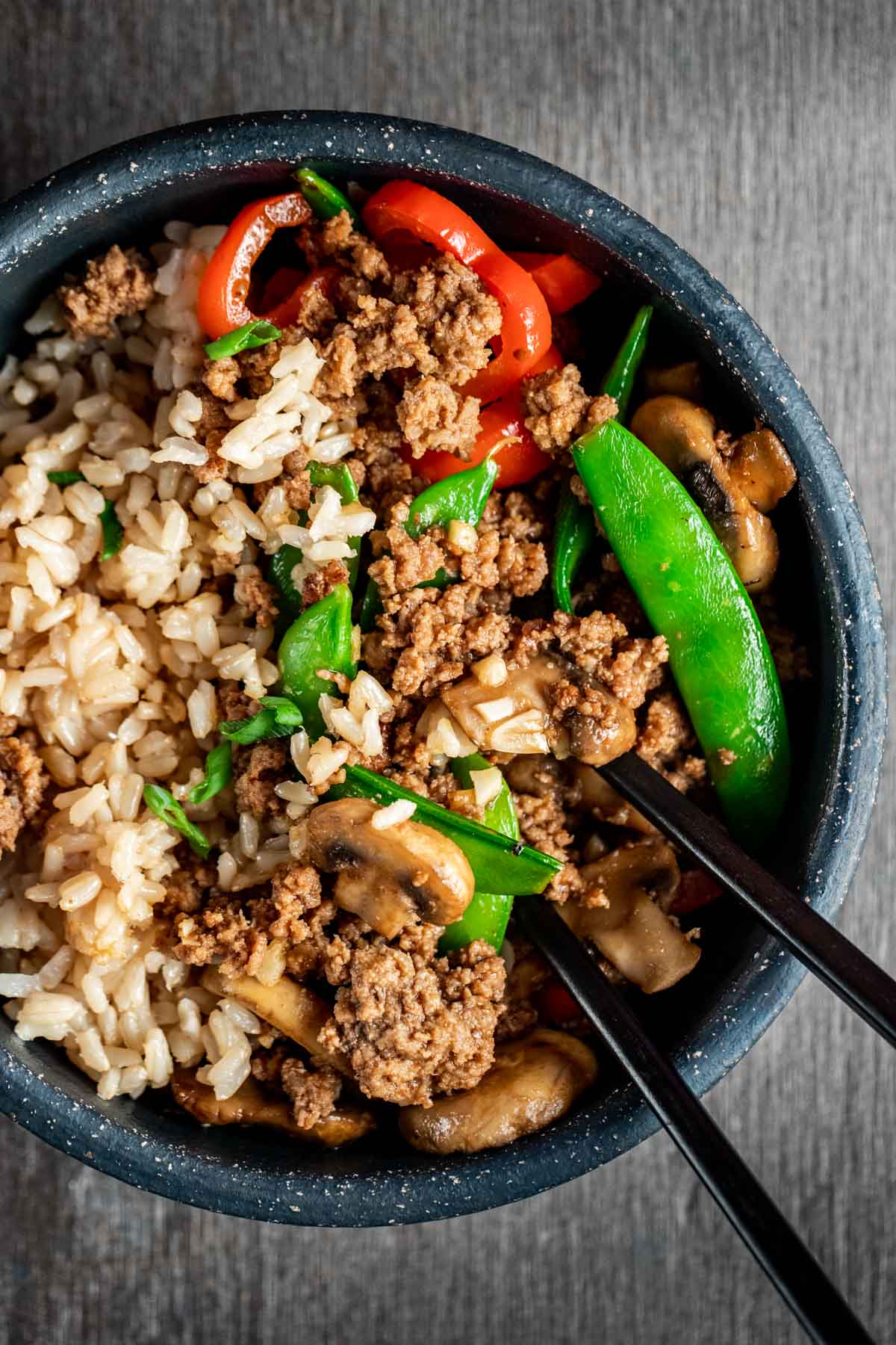 Stir fry ground beef served with rice in a bowl.