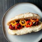 sausage link on a white hot dog bun with red and yellow sausages