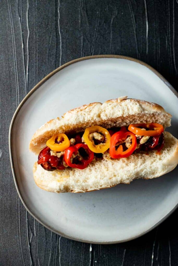 sausage link on a white hot dog bun with red and yellow sausages
