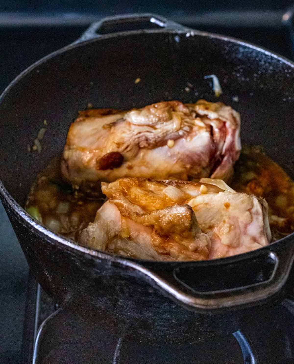 view of pork in a dutch oven with broth