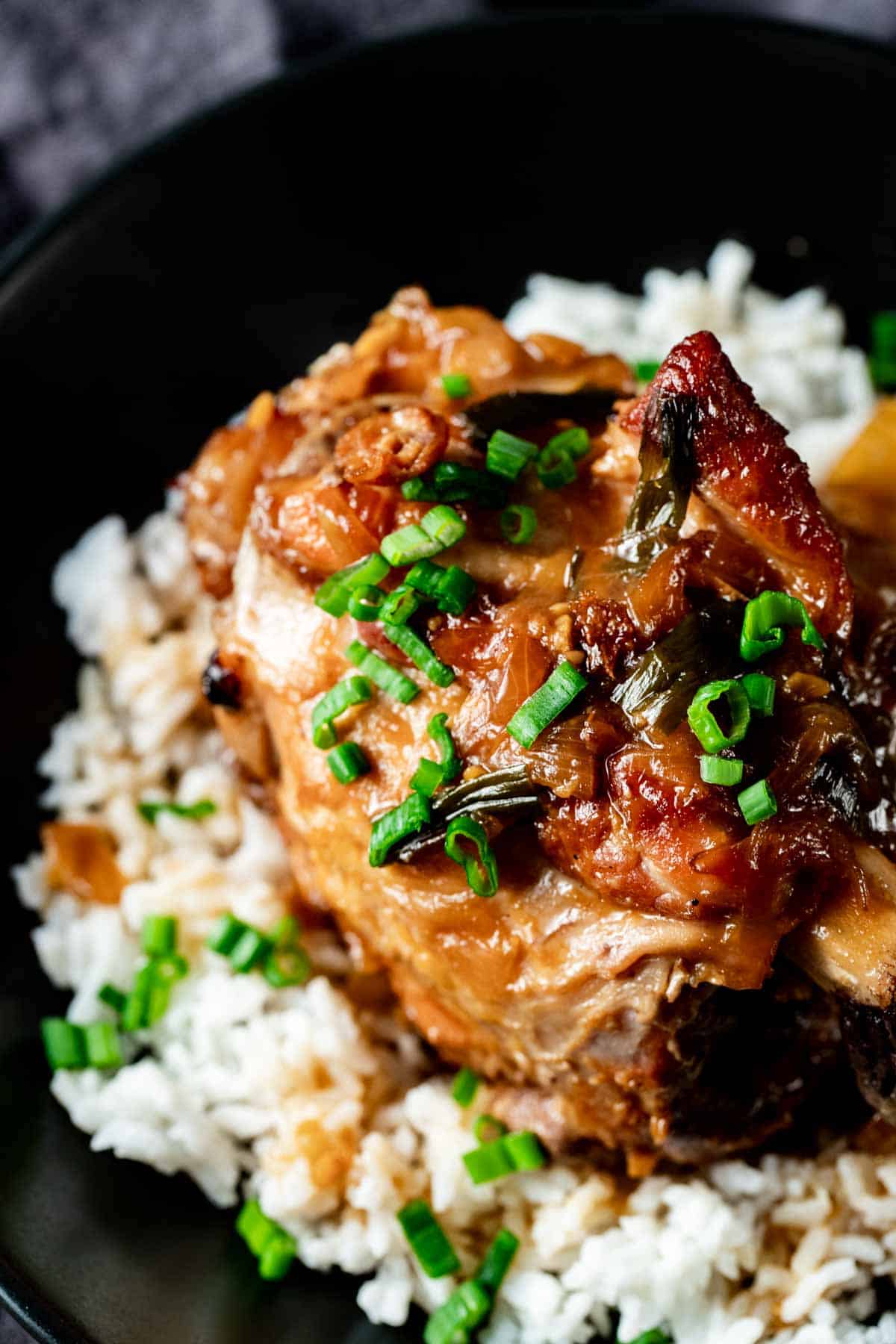 pork shanks on a bed of rice on a black plate for serving
