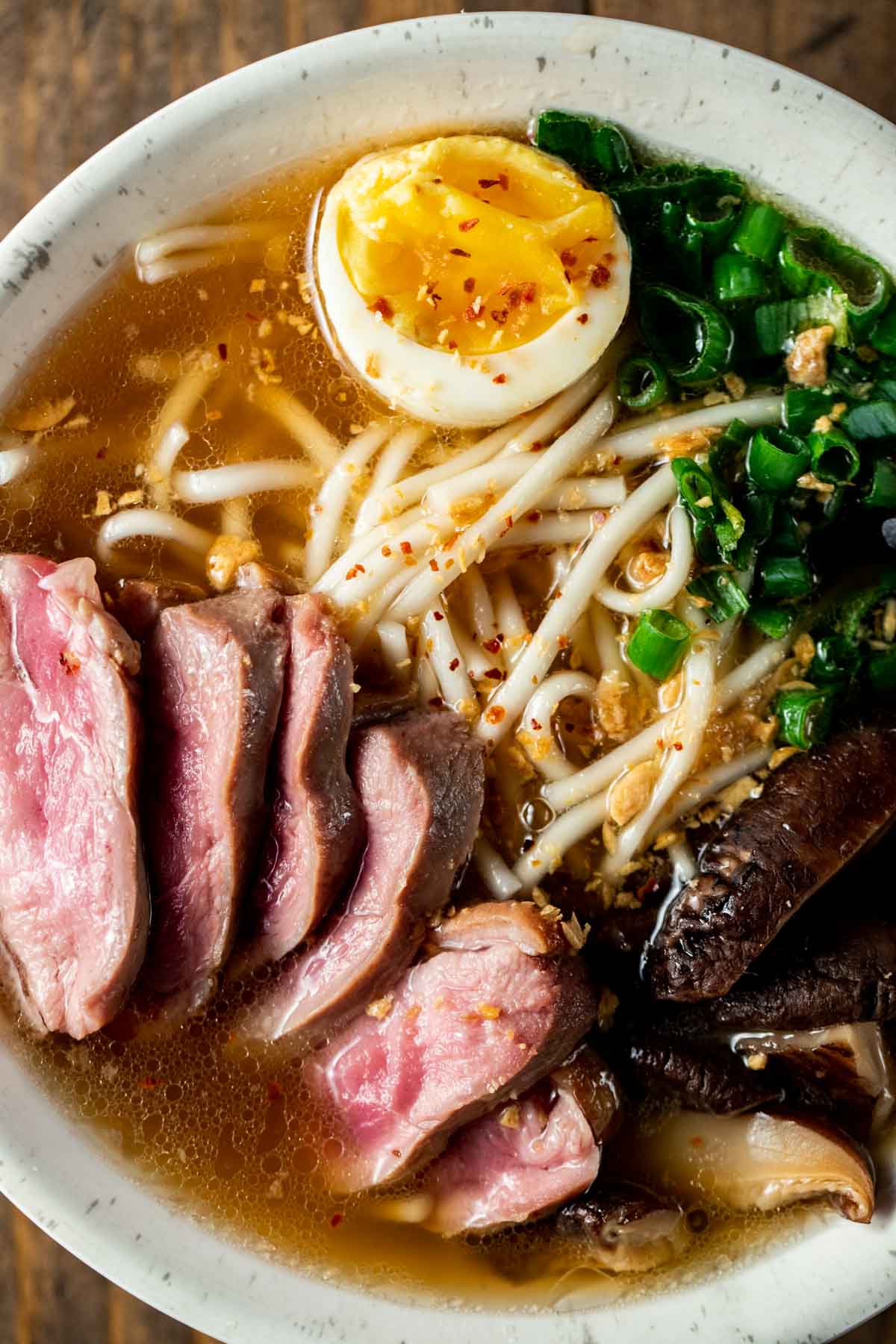 up close view of duck ramen in a white bowl