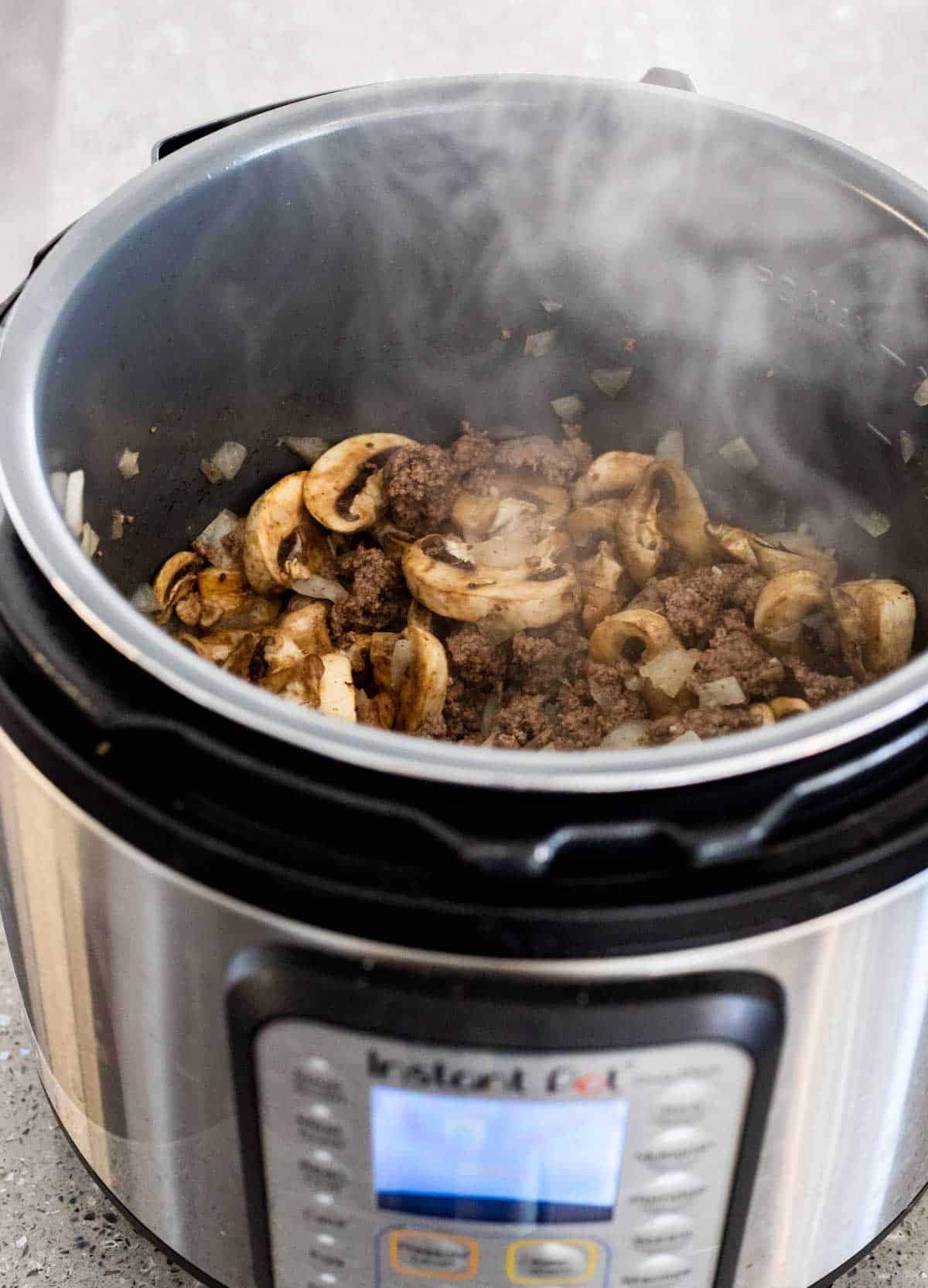 mushrooms cooking in an instant pot with ground beef