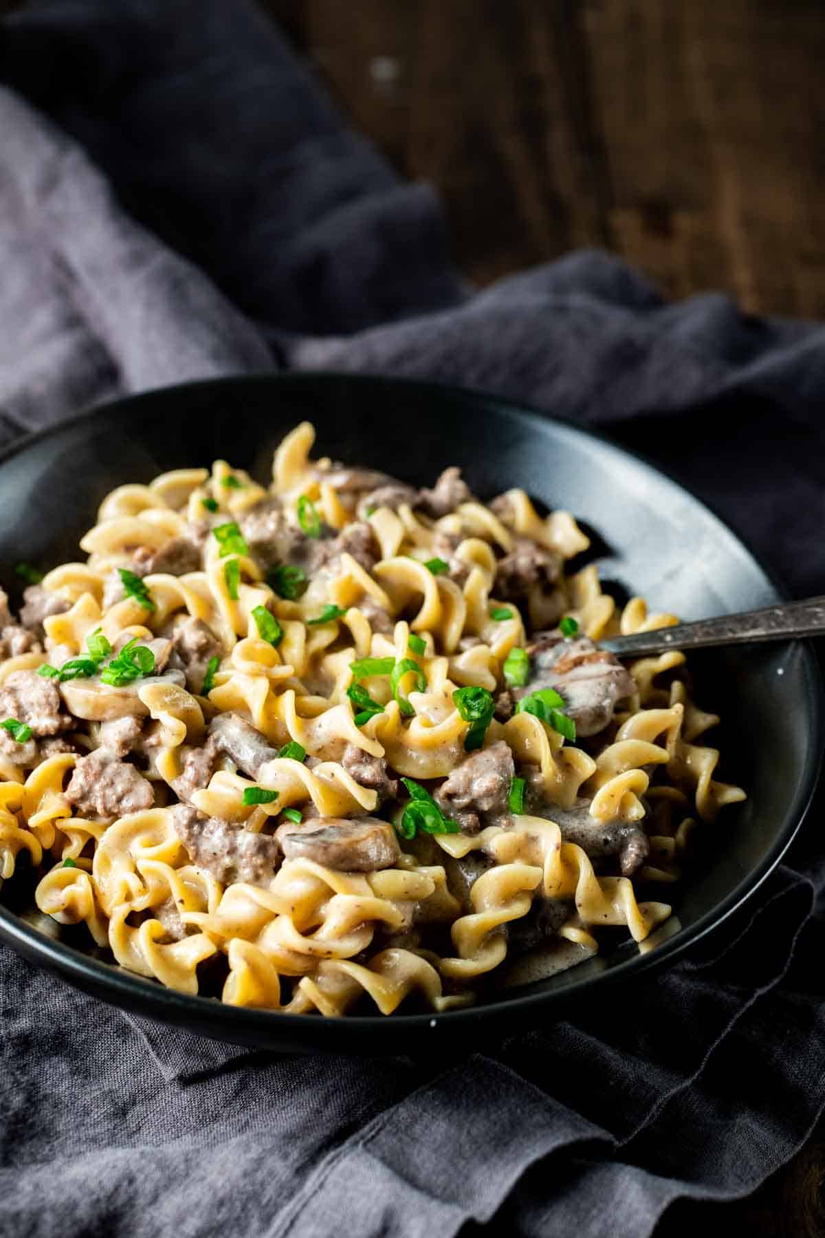 spiral pasta with a creamy mushroom and beef sauce garnished with parsley