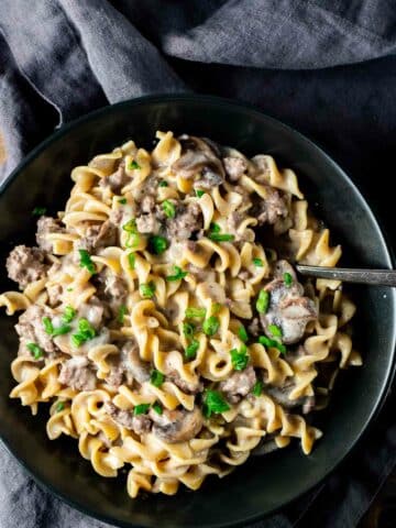 creamy noodles and beef in a bowl with a spoon