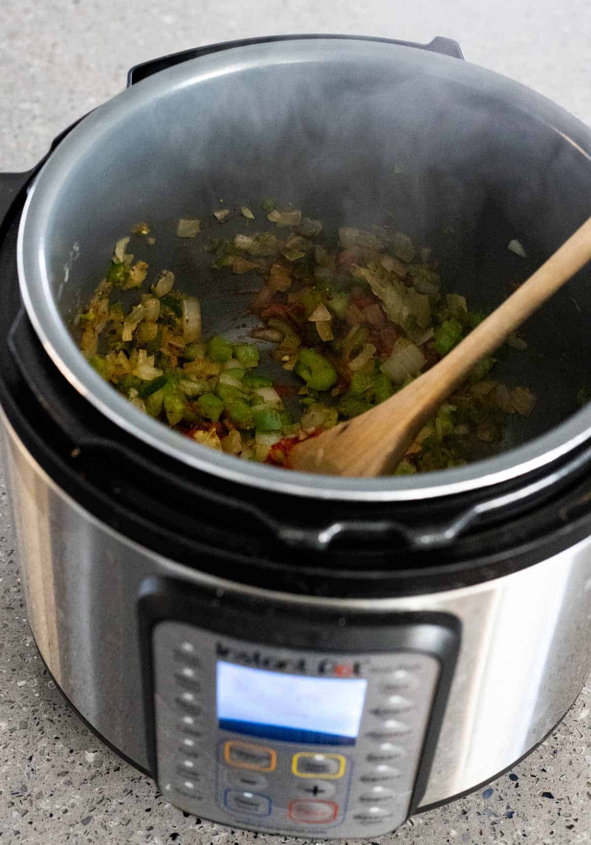 view of ingredients in the instant pot with steam coming out 
