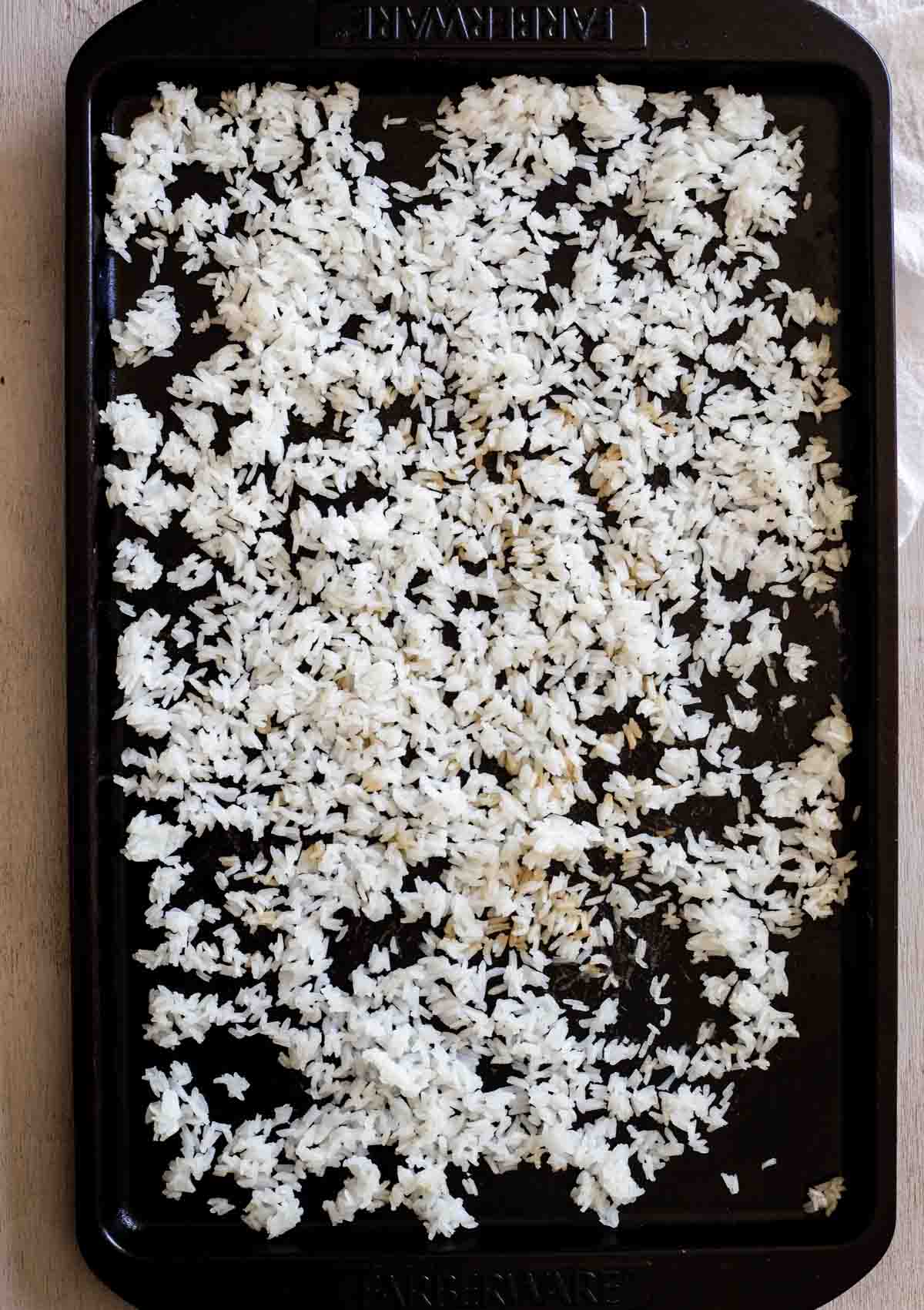 white rice spread on a baking sheet