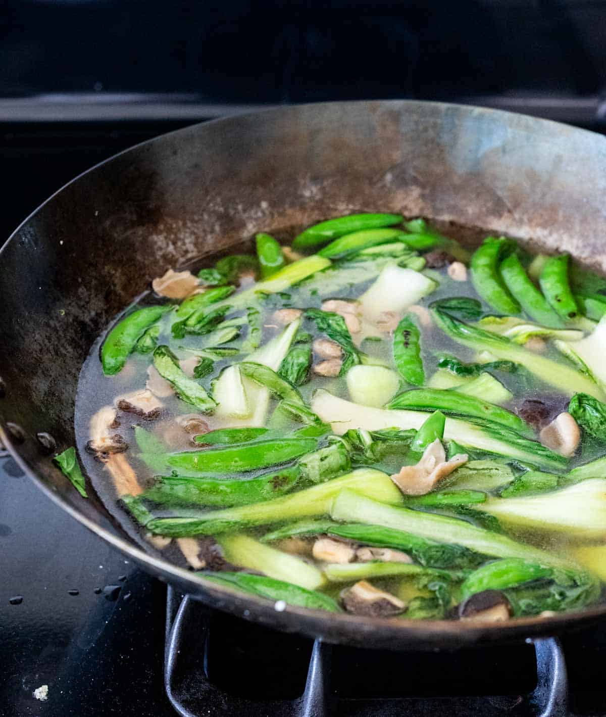 vegetables in a broth in a wok