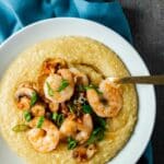 shrimp and grits topped with green onions in a white bowl