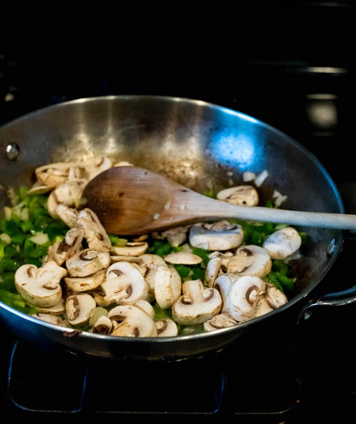 peppers and mushrooms cooking in a skillet