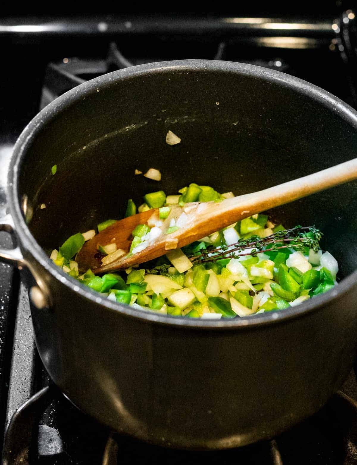 green peppers and onions being cooked in a pot