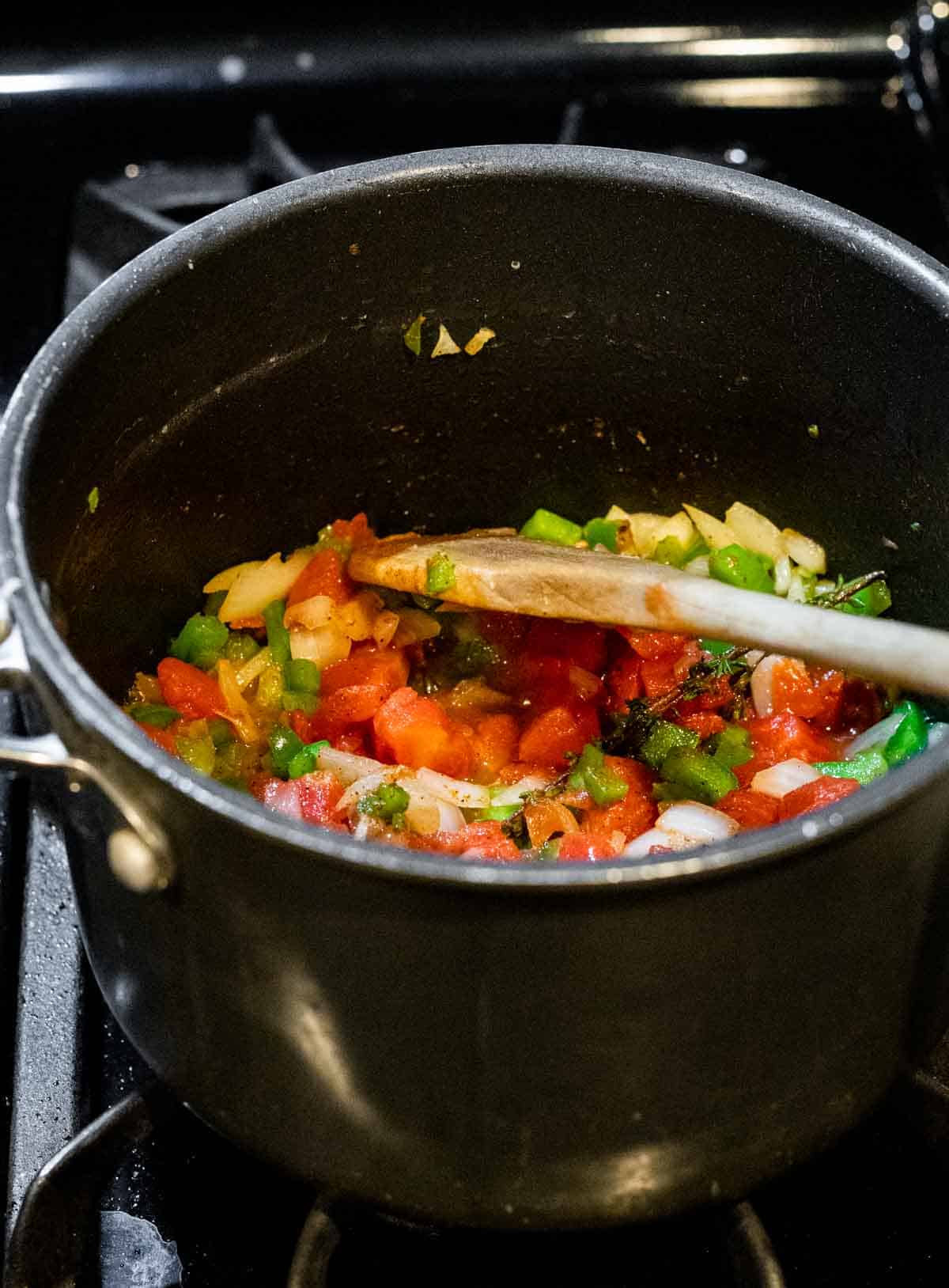 pepper, onions and tomatoes cooking in a pot